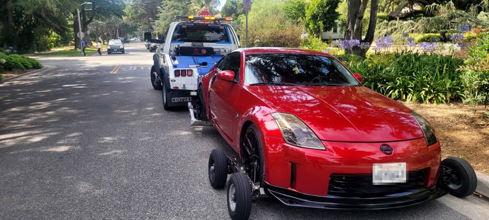 Los Angeles Towing flatbed towing a car on a residential LA street